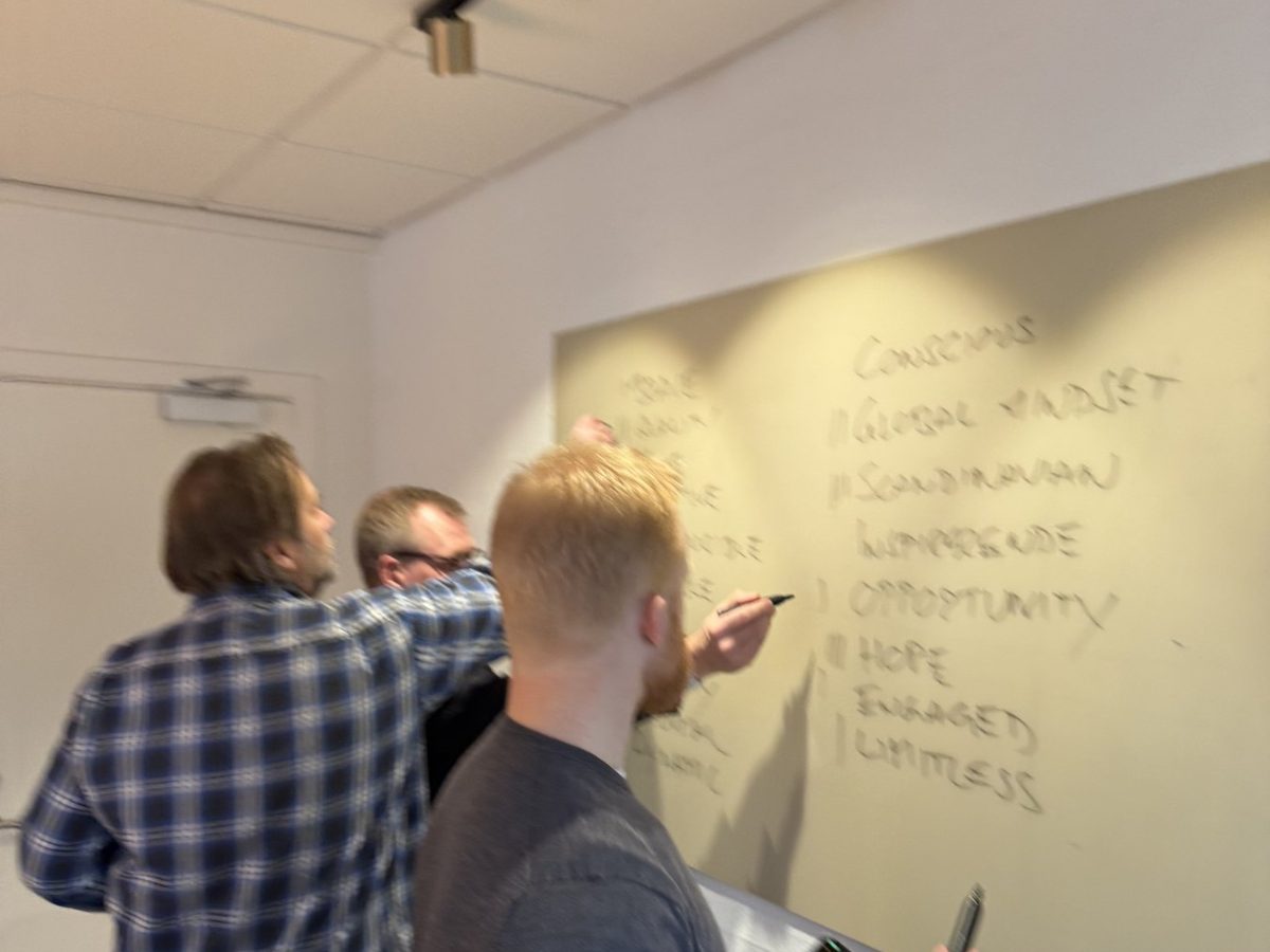 Deltakere arbeider ved tavlen på et internt Enneagram-forløp